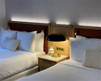 Aura Hotel room with nightstand and lamp
